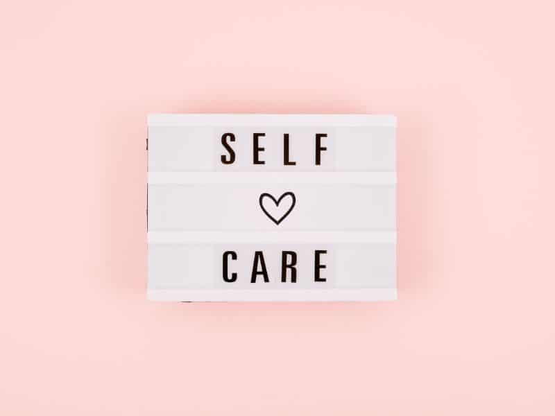 Self-care written on a pink background